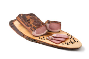 Bio Kotelette Speck Räucherfleisch auf Holzbrett präsentiert